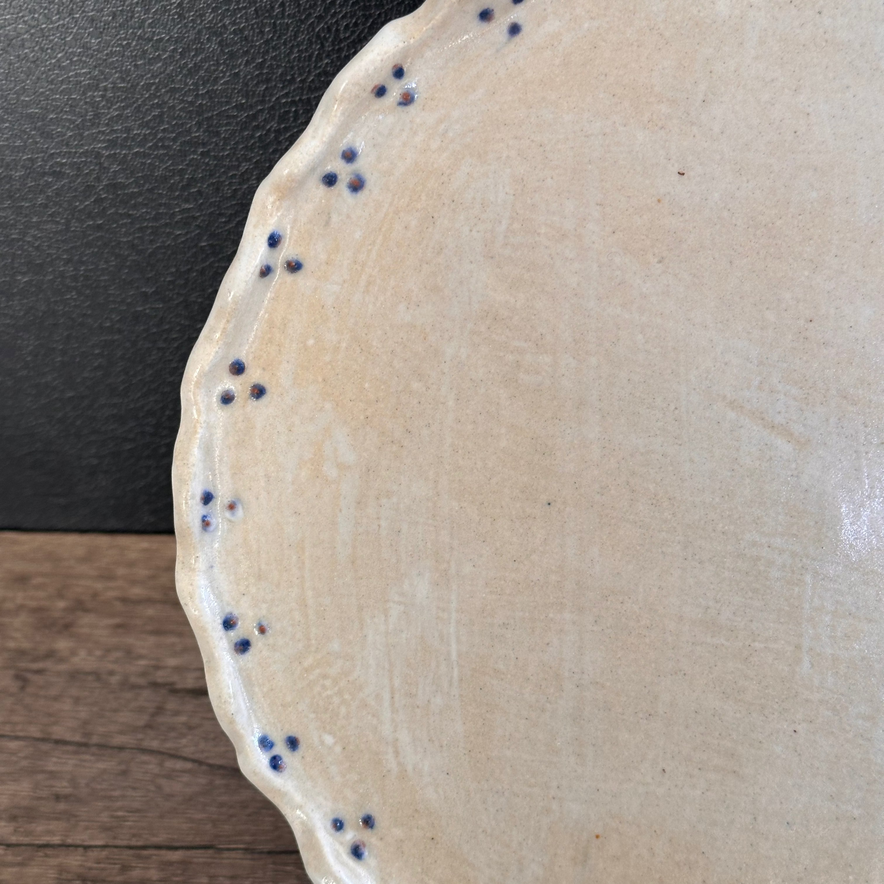 stoneware handmade functional and decorative plate with blue dots and scalloped rim